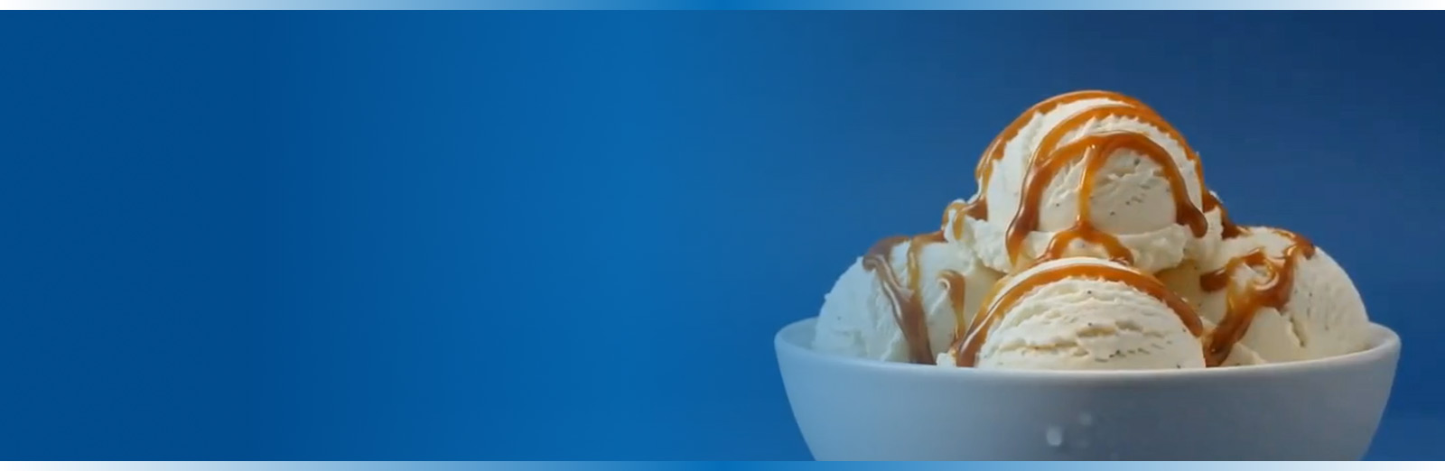 A bowl of ice cream with caramel syrup on top